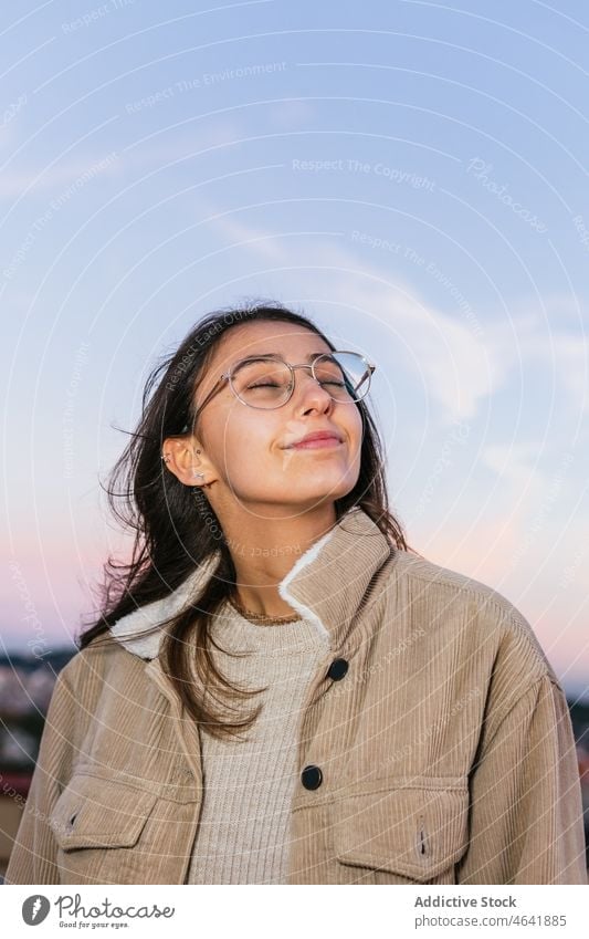Delighted woman in eyeglasses at sunset teen carefree happy charming sundown personality portrait glee delight female glad individuality toothy smile
