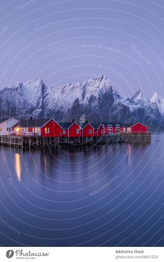 Picturesque view of calm river near cottages and snowy mountains village winter shore ridge house range settlement sky reine norway lofoten town scenic water