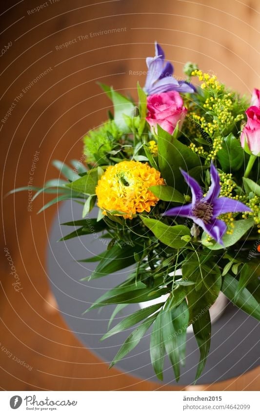 a colorful bouquet of flowers stands on a small gray side table Spring variegated Ostrich Bouquet Pink Flower Blossom Decoration Blossoming Interior shot Table