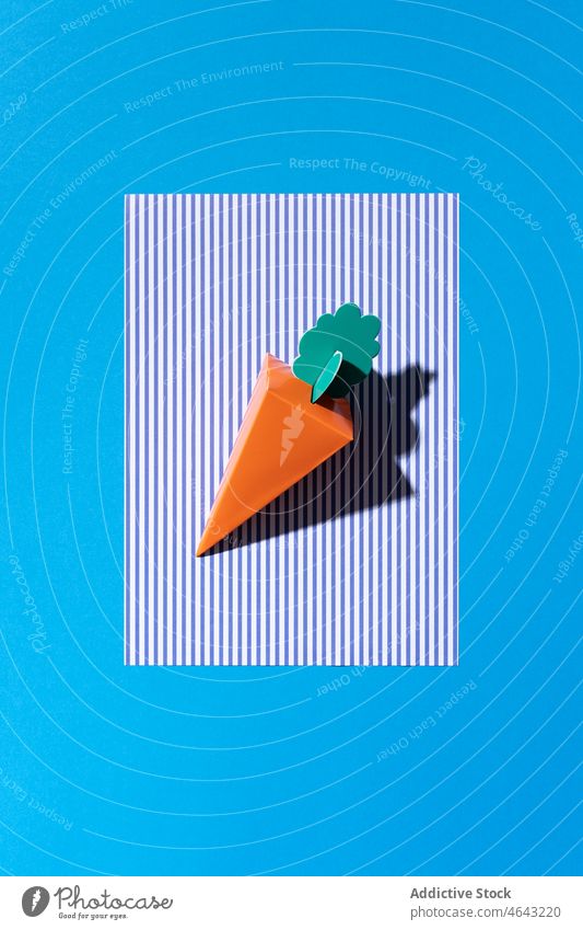 A cardboard carrot on a blue background easter paper food cartoon color nature texture realistic rabbit spring cardboard background color cardboard paper effect