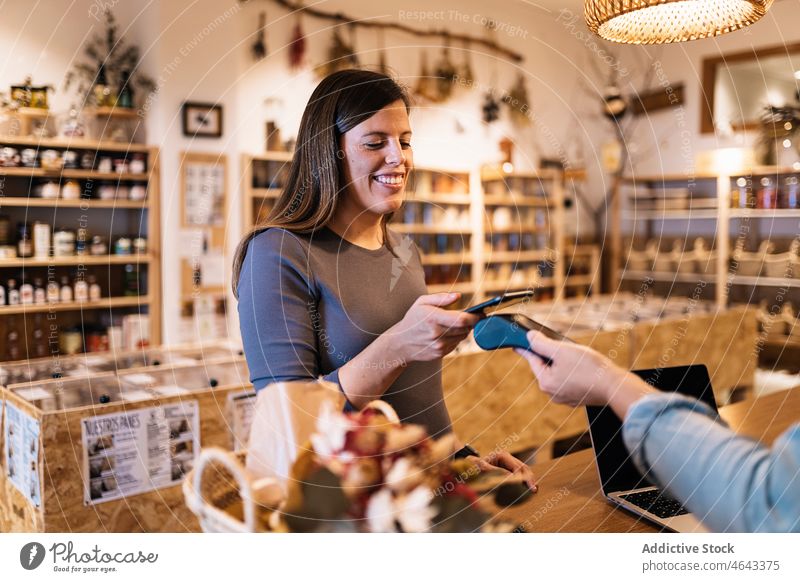 Pregnant female paying with smartphone in eco friendly store women contactless terminal seller shop customer client purchase counter buyer mobile small business
