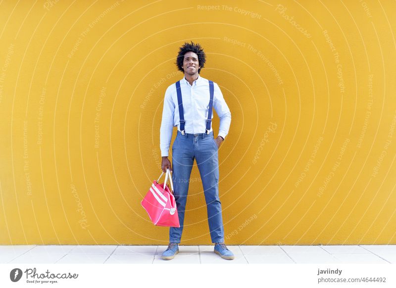 Stylish black man standing against yellow wall style smart casual city smile cheerful outfit well dressed street happy male african american ethnic entrepreneur