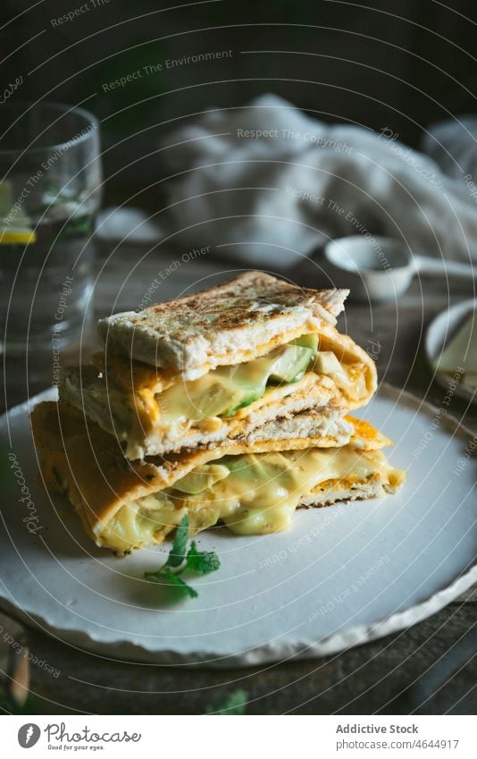 Avocado omelet sandwich served on ceramic plate delicious snack gourmet ingredient food bread avocado lunch healthy breakfast dinner toast vegetable cheese