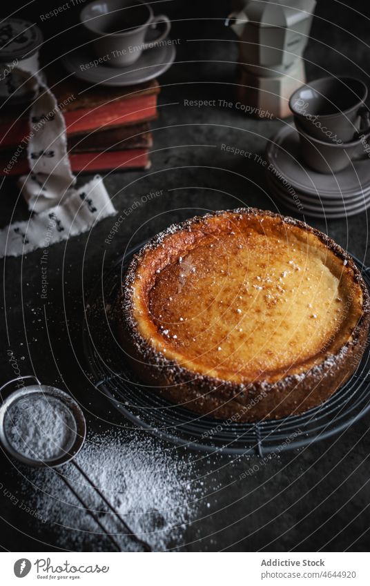 Delicious hot cheesecake on baking pan near glassware on table tray homemade delicious tasty aromatic strainer sweet powder pastry yummy dessert food appetizing