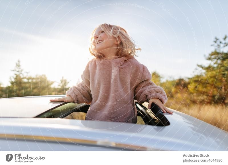 Cute girl in sunroof of car child road trip pastime passenger countryside automobile leisure commute vehicle journey transport adventure automotive open cute