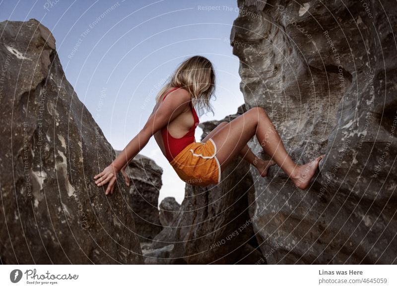 It’s always a great idea to visit Vietnam. Climb some rocks and show your beautiful long legs. Dressed in a red swimsuit and orange shorts. Like this gorgeous blonde girl.