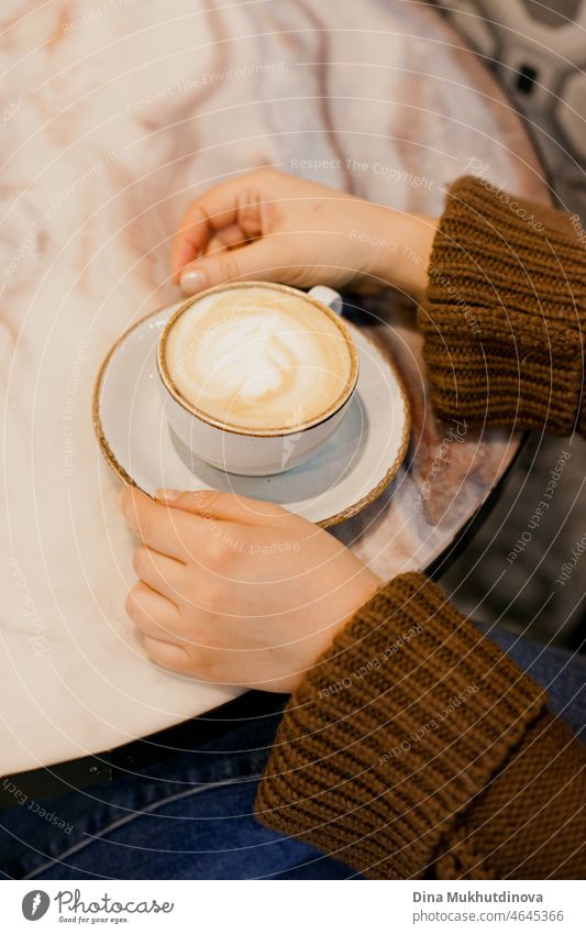 Woman drinking coffee - hands holding a cup of cappuccino coffee at cafe on marble table caffeine desk liquid copy space coffee cup break relaxation no people