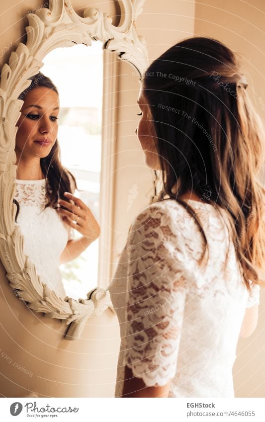 Bride before the wedding looking at herself and combing her hair in the mirror nervously. Important day. Wedding and marry concept. reflections wife
