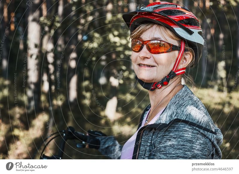 Active woman cycling on forest road. Female riding bicycle off-road route on summer vacation day trip adventure biking recreation travel bike action activity