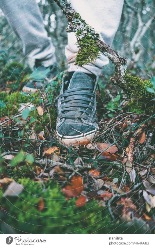Detail of a foot with a sneaker walking in the forest close shoe dirty vintage retro high soil earth explore exploration environment old vegetation organic