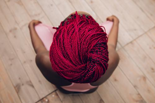 closeup of the red braids of a woman doing meditation active slim activity asana african american athletic trainer balance beauty adult concept health