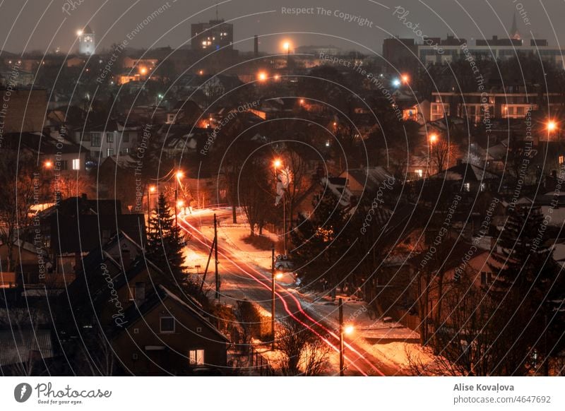 houses in the city at night latvia town night lights cars winter snow Colour photo Streets foggy night roads homes trees