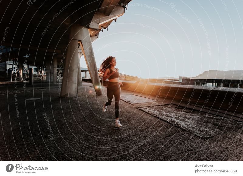 Two young girls jogging during a sunset, backlighting, train on ruban ambient concept. Working out clothes, top and leggings, African woman fitness. Sunset ambient, slim bodies.