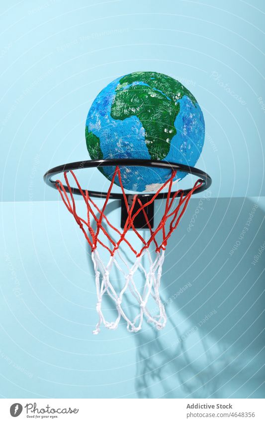 Small Earth ball in basketball hoop earth planet globe catch concept global save protect geography environment round color shadow world form sphere colorful