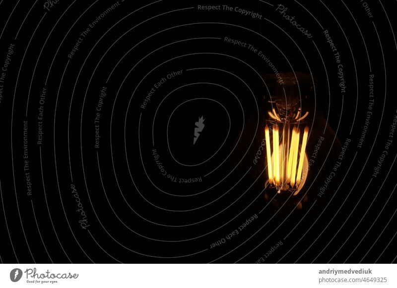 Classic Edison light bulb on black background with space for text retro vintage fashion design globe coffee technology art electricity energy glass lamp bright