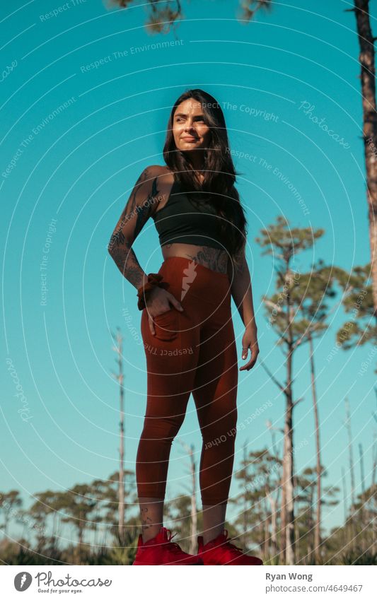 Spanish young woman standing in park with the sun on her face. forrest state park scenary travel elegance hispanic latina clear sky blue confident motivated