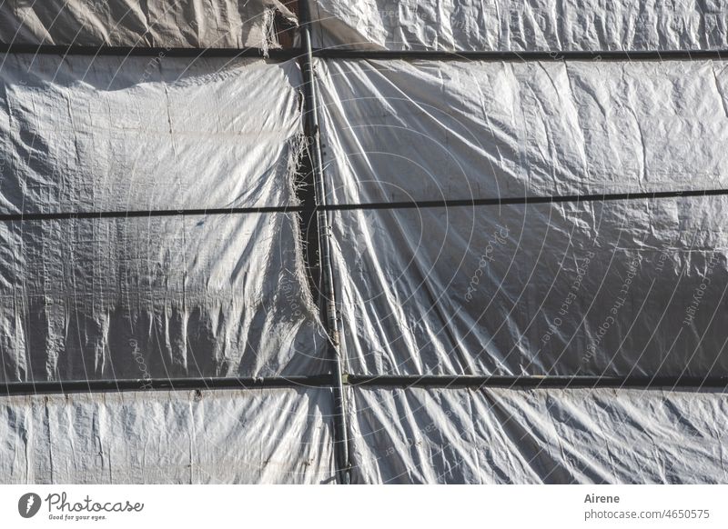 strung to breaking point Crack & Rip & Tear tarpaulin Scaffold Construction site Shadow crease Scaffolding Screening Safety secure seal off behind Redevelop