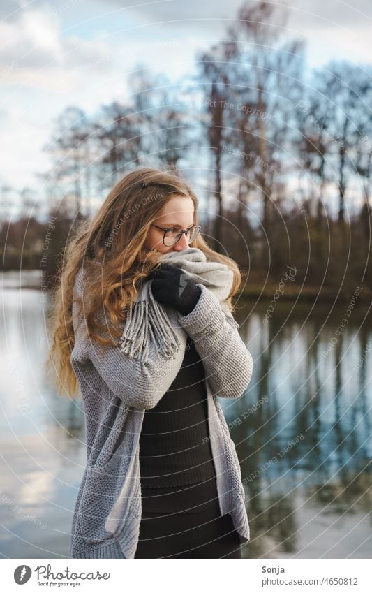 A young freezing woman with glasses and long hair wrapped in a scarf. Woman youthful Freeze Scarf Winter chill Eyeglasses long hairs Lifestyle Exterior shot