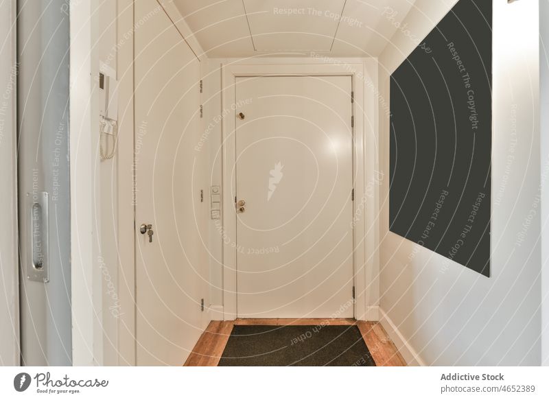 Closed door at entrance of apartment corridor residential condominium property flat accommodation home hallway doorway board dwell estate house contemporary