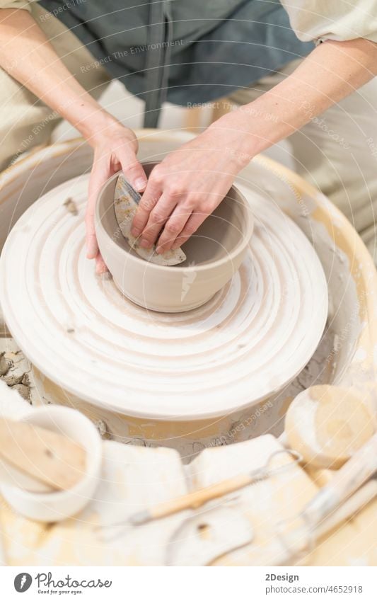 Female ceramic artist in apron working in pottery workshop hobby clay craft hand bowl creativity making skill female woman manufacturing creation wheel shape