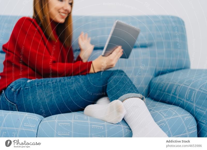 Crop woman with tablet at home using browsing rest weekend online internet video call female surfing chill couch sofa free time connection relax pastime talk