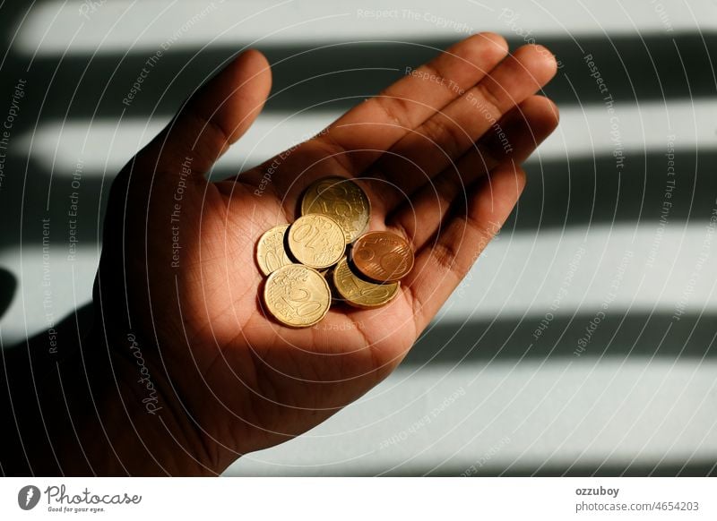 Close up hand holding euro cent coin with light and shadow pattern as background. Finance concept. currency cash finance money investment saving person business