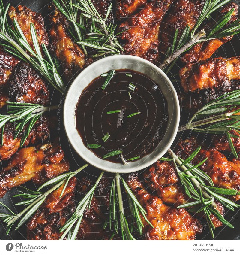 Close up of BBQ chicken wings with rosemary and homemade sauce close up bbq cooking meat delicious finger food top view chicken meat dinner herbs lunch marinade