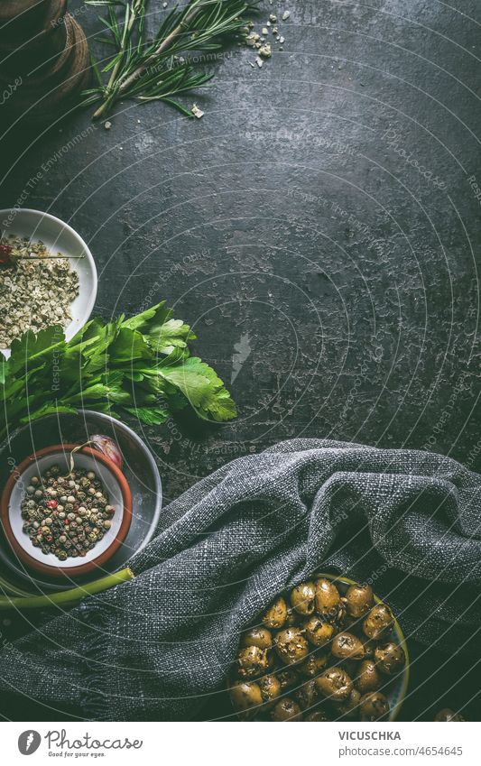 Food background with bowls of  olives, herbs and pepper food background dark kitchen table dish towel cooking preparation top view copy space italian food