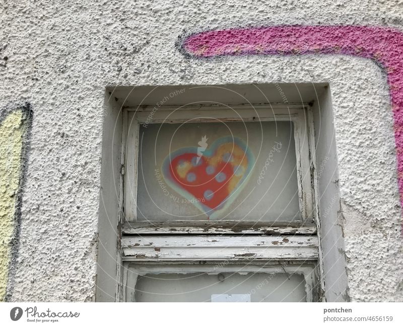 A heart was sprayed on an old window of an industrial building. Graffiti. Heart Vandalism Youth culture Window dilapidated Building Industrial building Facade
