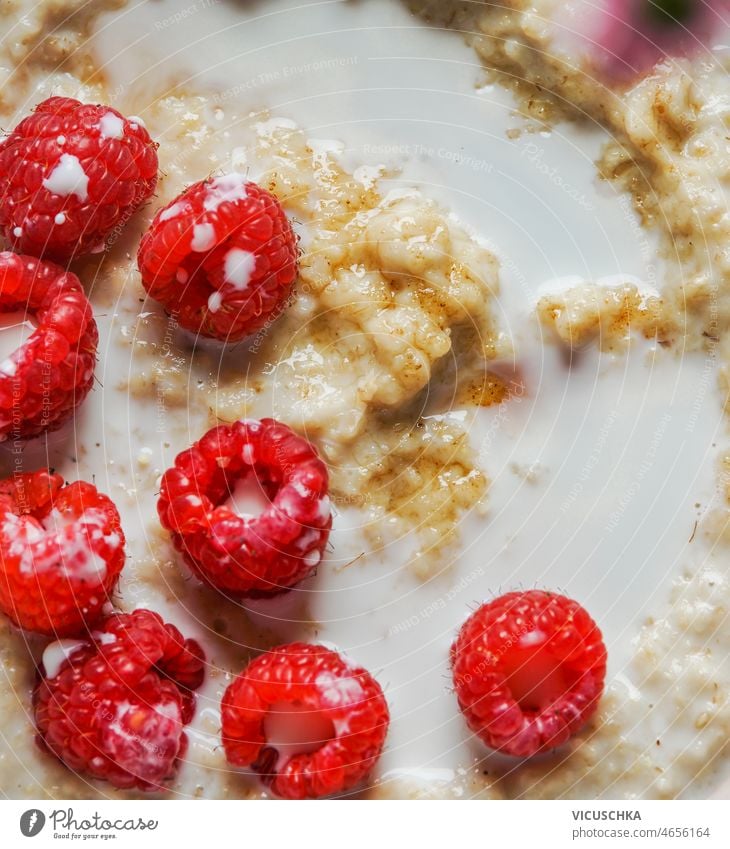 Closeup of porridge with milk, oats and raspberries. Healthy breakfast close-up healthy seasonal summer berry top view food bowl breakfast idea close up