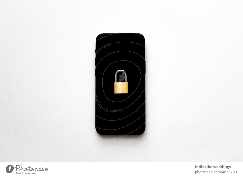 An isolated black smartphone with a small padlock on it on white background. Phone protection idea. Online data privacy protection concept. Protection against cyber attack.