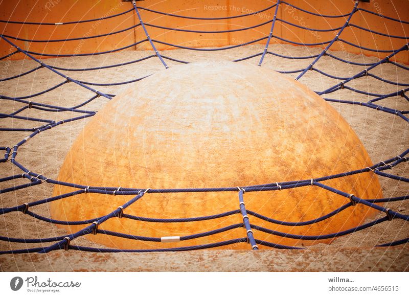 Skillfully camouflaged UFO. Spider web-like climbing net around a hemisphere, on a children's playground. They are among us. Net Playground balance Balance