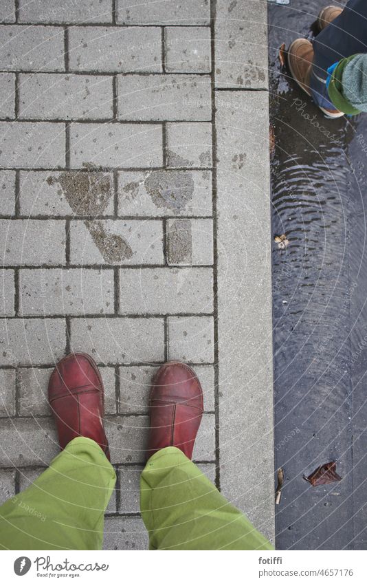 A bird's eye view of red-shod, green-shod women's legs standing on cobblestones | Rotfußgrünhos Footwear Stand Bird's-eye view Paving stone Exterior shot Street