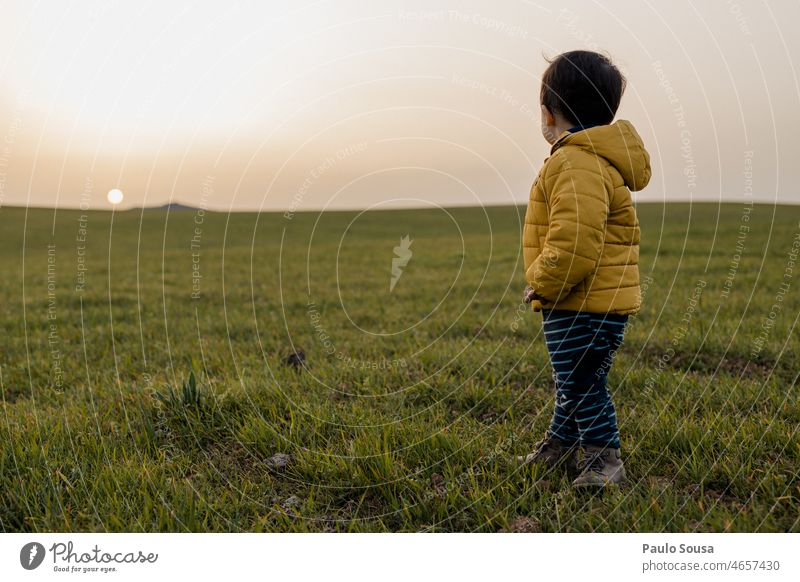 Child with Yellow hooded jacket looking at sunset Boy (child) 1 - 3 years Day Infancy Colour photo Toddler Exterior shot Lifestyle Shallow depth of field