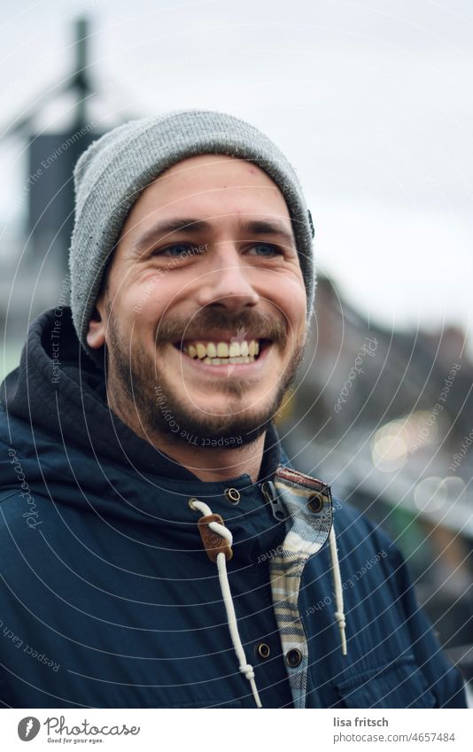 HAPPY - MAN - LAUGH - WINTER Man 30-35 years Facial hair Brunette Cap Winter Cold cheerful Happiness Adults Colour photo Exterior shot Smiling fortunate