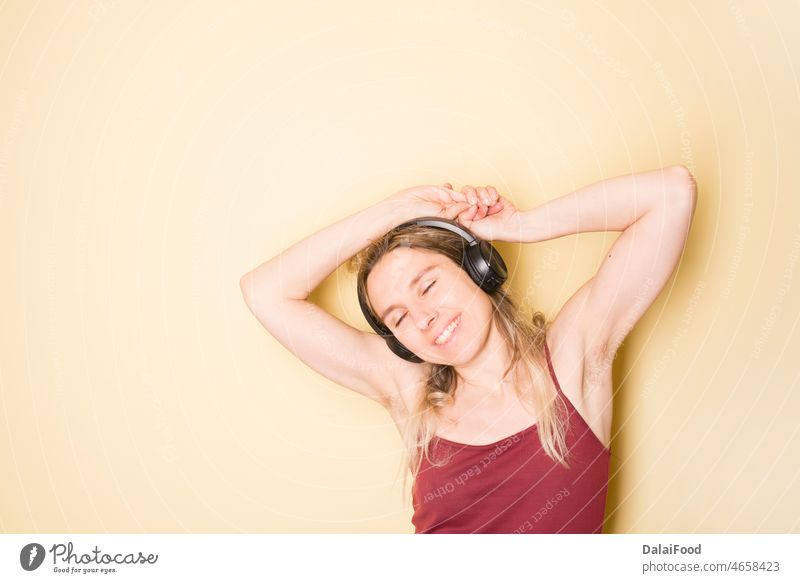 happy woman listening to music deadphone yellow background