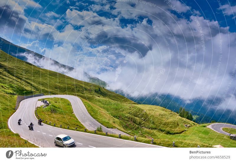 Motorcycles on pass road. Clouds against blue sky. Grossglockner high alpine road Mountain Alps Landscape Panorama (View) Austria Sky motorcycles curvaceous
