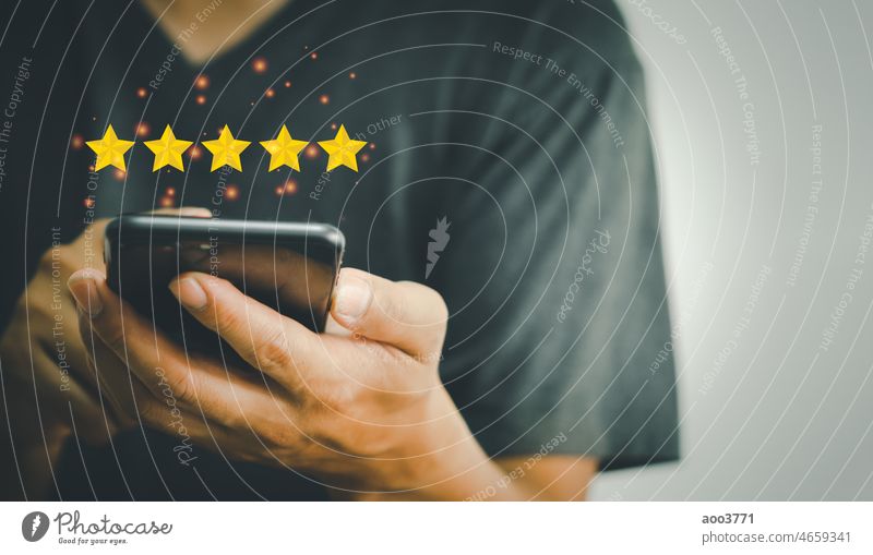 Hand using phone holding 5 stars on hands.Customer satisfaction and marketing survey rating concept feedback review success business quality positive best