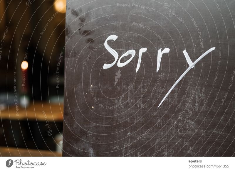 A handwritten sorry on a sign at a cafe Apology Remorse Characters Emotions Communicate Signs and labeling Moody Café sold out Chalk writing Word Individual