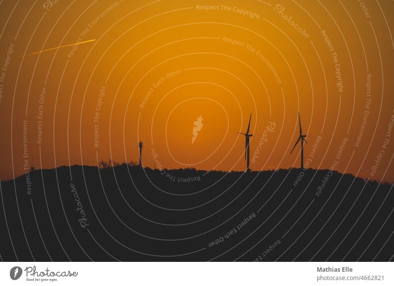 Power generation by wind turbines in the sunrise eco-power Wind energy plant Field Generator Silhouette Climate protection Evening renewable energies