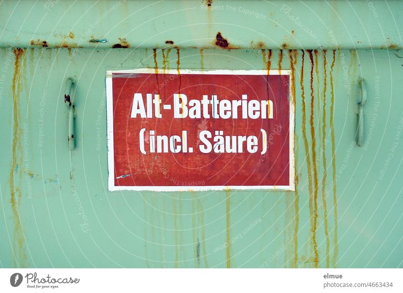 Old batteries (incl. acid) is written on a red sign on a green container with rust traces due to sulfuric acid Disposal Old battery Battery Lead-acid battery