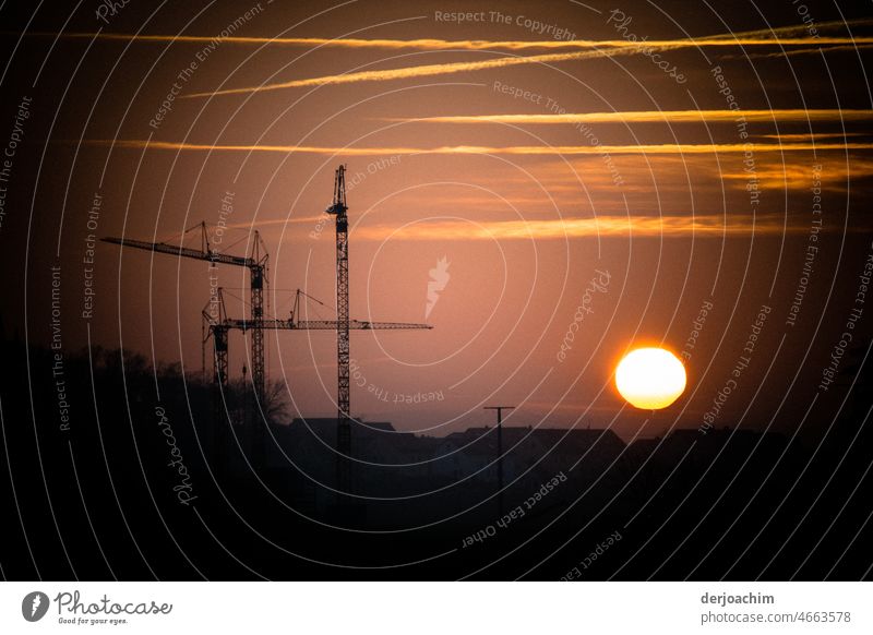 The construction cranes are at a standstill and the evening sun is about to disappear on the horizon. Sunset Nature Dusk Landscape Exterior shot Colour photo