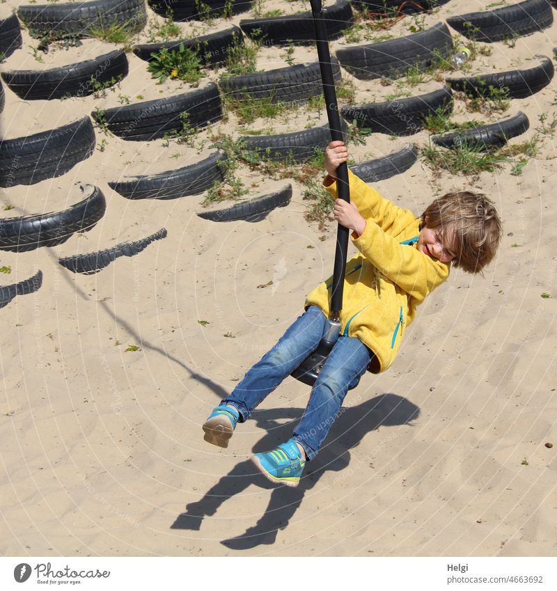 Swing fun - child swinging in the sunlight on a giant swing , shade in the sand Human being Child Boy (child) Infancy Joy To swing Giant swing Sand Shadow