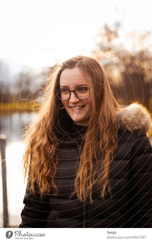 A young smiling woman with glasses and long hair. Woman youthful Long-haired Smiling Eyeglasses Winter portrait Human being Adults Feminine Colour photo