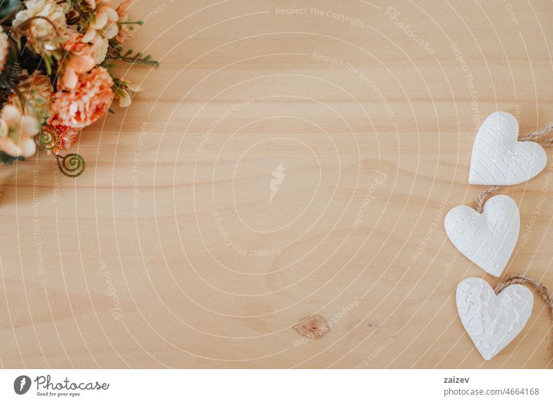 wooden table with an flowers and a heart white copy space background floral bouquet bunch nobody workspace desk creative decor minimal design workplace styled