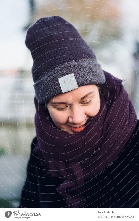WINTER - PURPLE - CAP - GRIN Winter Woman Young woman 25-29 years Cap Scarf purple Nose ring Grinning Smiling look down Exterior shot Adults Colour photo