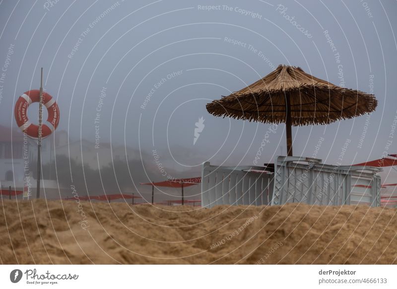 Fog on Sao Pedro de Moel beach in Portugal with life belt and sun umbrella Nature Environment abandoned place forsake sb./sth. coast Ocean Emotions Loneliness