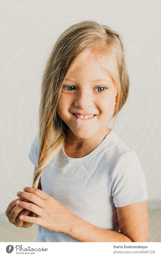 Sweet Girl 7 years old blonde with blue eyes hair playful hand finger lovely pretty expression portrait showing caucasian happy beautiful white female girl
