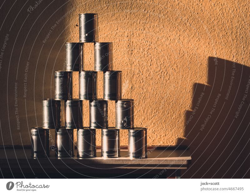 Pyramid from cans with shadows Pyramid of tins Preparation List Target Tin Neutral Background Structures and shapes Stack Row Towering Containers and vessels