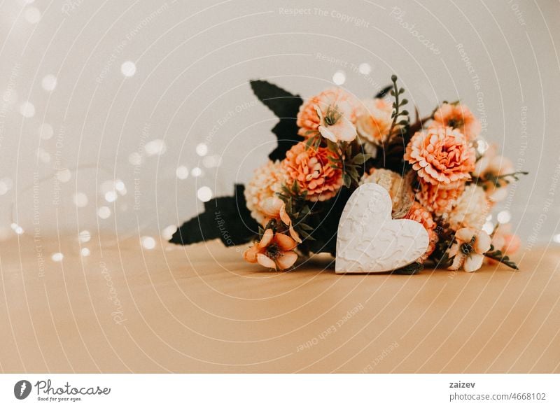 wooden table with a bouquet of flowers and a white heart copy space background floral bunch nobody bokeh lights workspace day writing blossom wedding valentine